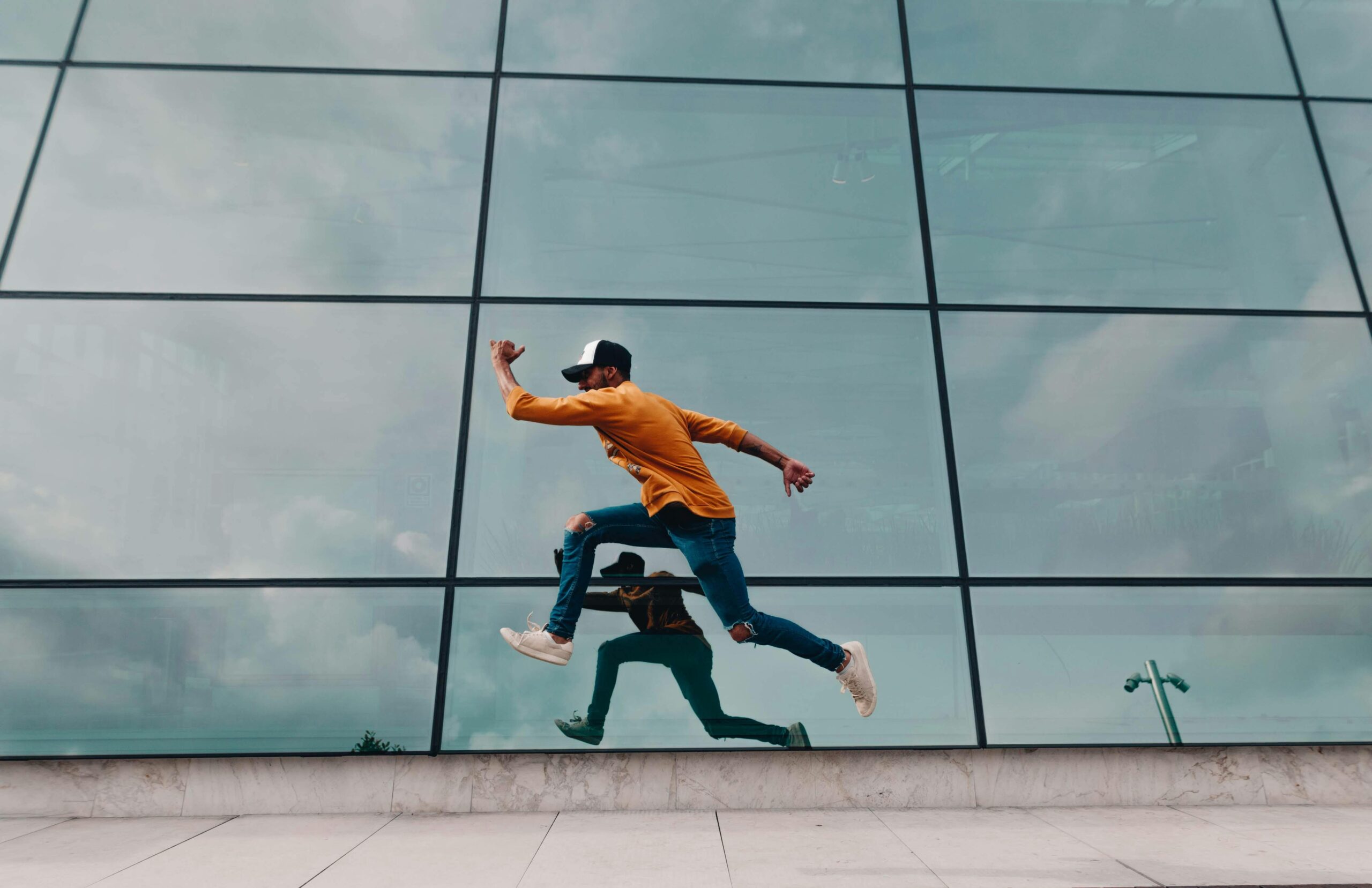 Man running in front of a glass building